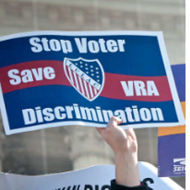 Red white and blue sign saying Stop Voter Discrimination Save VRA