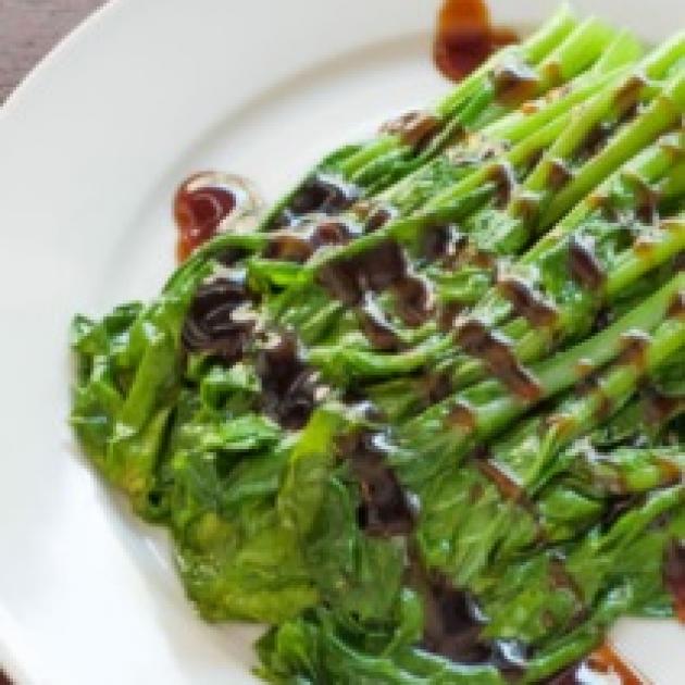 Asparagus on a plate with a brown drizzle across it