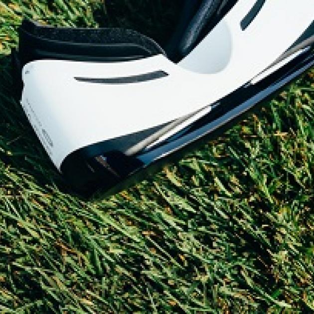 White and black virtual reality goggles laying on grass