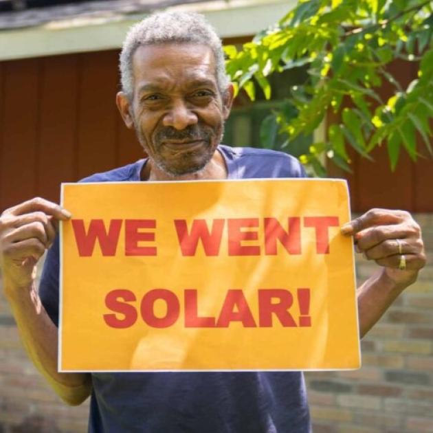 Man holding We Went Solar sign