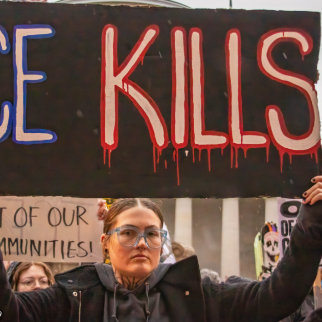 Woman with ICE Kills sign