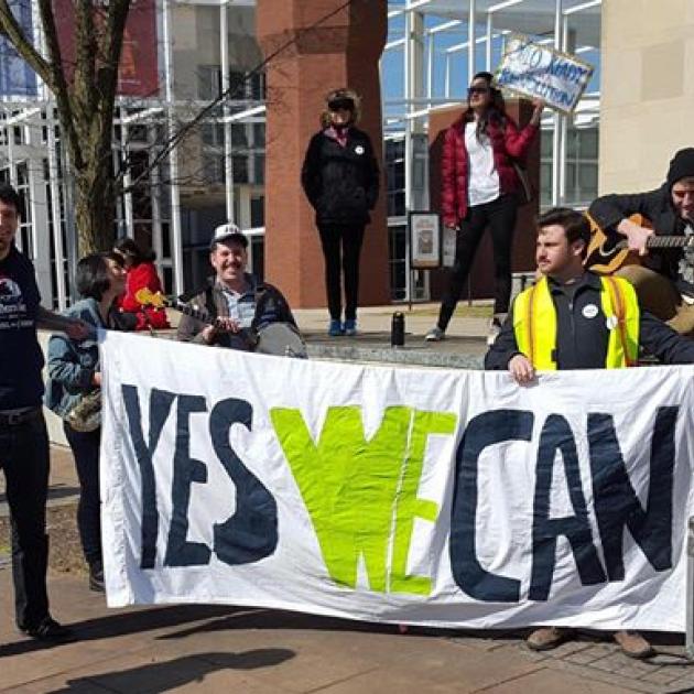 People holding Yes We Can sign