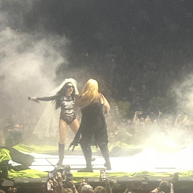 Women on stage at a concert with lots of smoke