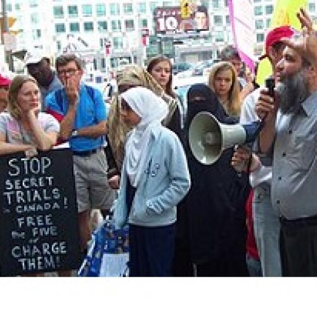 People protesting outside with sign saying Stop secret trials