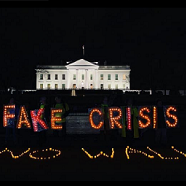 PHoto of white house with neon lights in front against black saying FAKE CRISIS NO WALL