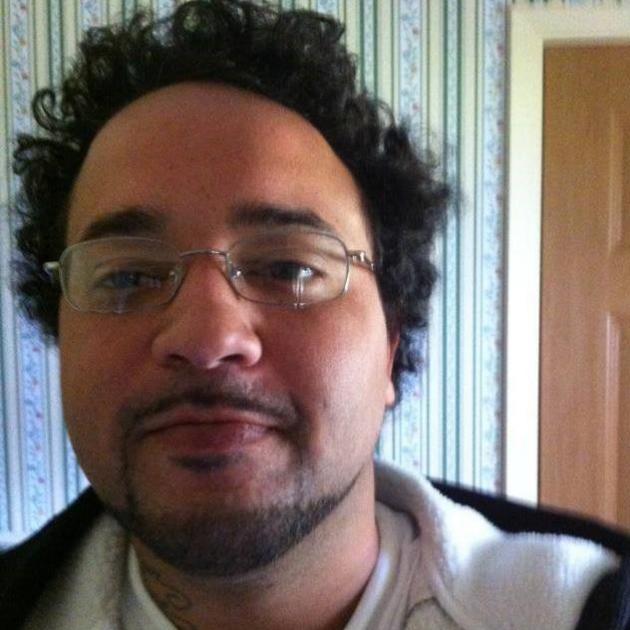 Photo of young black man with wire-rimmed glasses