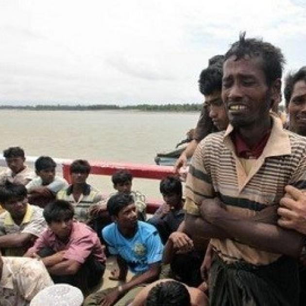 Lots of men of color on a boat, one in the foreground looking very distressed