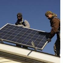 Two guys on a roof installing a solar panel