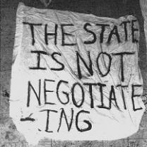 A crudely hand lettered sign on what looks like a sheet saying The state is not negotiating