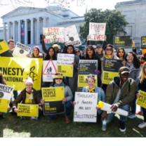 People posing outside with Amnesty signs
