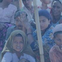 Photo of many women wearing headscarfs and looking very worried