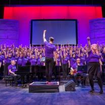 Chorus and conductor with raised fists