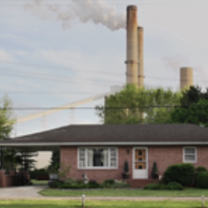 House with coal plant in background