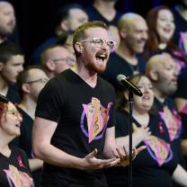 Man singing in front of chorus