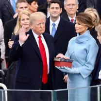 Donald Trump frowning with hand on Bible at swearing in ceremony