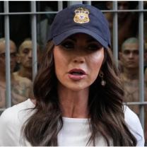 Woman in baseball cap in front of El Salvador prison