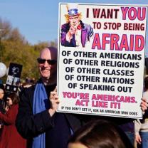 Man outside holding a sign about what Americans fear