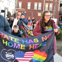 People marching with banner saying Hate has no home here