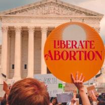 Sign in front of government building saying Liberate Abortion