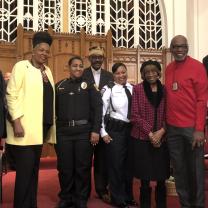 Several black men and women posing at a church 