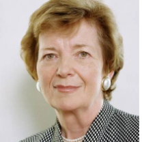 Middle aged white woman with earrings and a black and white suit