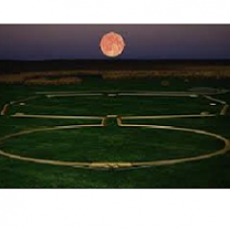 Green ground and dusky sky with huge red moon and a design on the ground