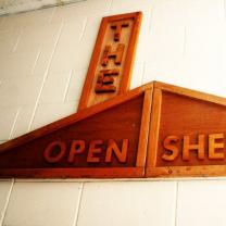 Wooden sign saying The Open Shelter