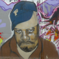 A black man wearing a blue baseball cap looking sad