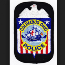 Red white and blue police badge with eagle at top and Santa Maria in the middle with words Columbus Ohio police