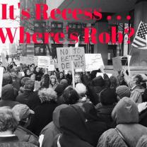 Black and white photo of people at a rally downtown with words It's Recess...Where's Rob?