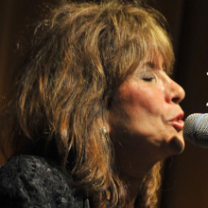 Sally Fingerett singing at a mic