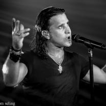 Scott Stapp with arms up singing