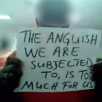 An inmate holding a sign saying The Anguish we are subjected to is too much for us