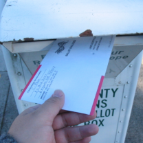 Hand putting mail in mailbox