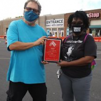Man and woman holding a plaque
