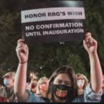 Man holding sign saying Honor RBG's wish
