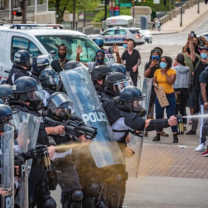 Police spraying a crowd of protestors