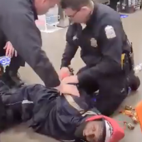 Cops holding a black man down