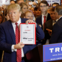 Trump holding up a sign