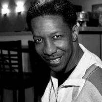 Black man head and shoulders, smiling