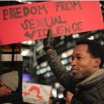 Black man holding a sign that says Freedom from Sexual Violence