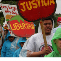 People outside marching holding signs Justica and Libertad