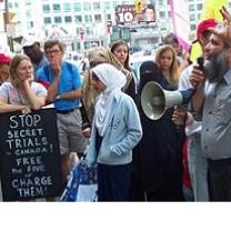 People protesting outside with sign saying Stop secret trials