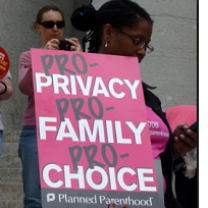 Black woman at rally holding a sign that says Pro privacy, pro family, pro choice