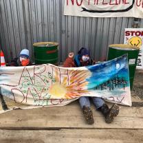 People sitting and holding an Earth Day banner