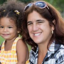 Young black girl with thirty-something white woman with brown hair and sunglasses on her head