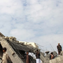 Broken down building against cloudy sky with young man standing around looking lost
