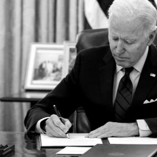 Biden at his desk signing something