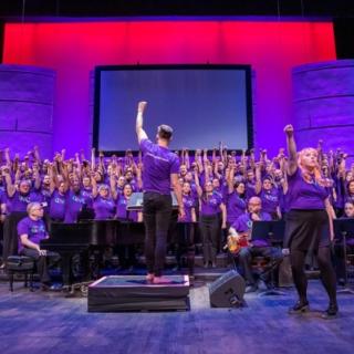 Chorus and conductor with raised fists