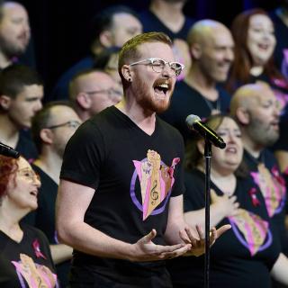 Man singing in front of chorus